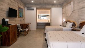 A hotel room with a wooden floor, a desk with a chair, two beds with white bedding, a TV mounted on the wall, and a large window. - Jilöo - Beautiful Oasis in Punta Zicatela (3) (Punta ZIcatela)