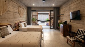 Une chambre avec deux lits, un hamac, une télévision et une vue sur l’extérieur.