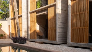 A modern building with a pool, wooden slatted walls, and a clear reflection in the water. - Jilöo - Beautiful Oasis in Punta Zicatela (3) (Punta ZIcatela)