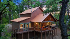 A cabin with a deck, large windows, and a chimney. - Secluded Cabin | Hot Tub | Game Loft (Broken Bow)