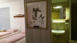 Un dormitorio con cama, mesita de noche y una obra de arte colgada en la pared.