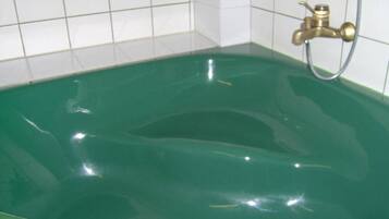 A bathtub with a faucet and a showerhead.