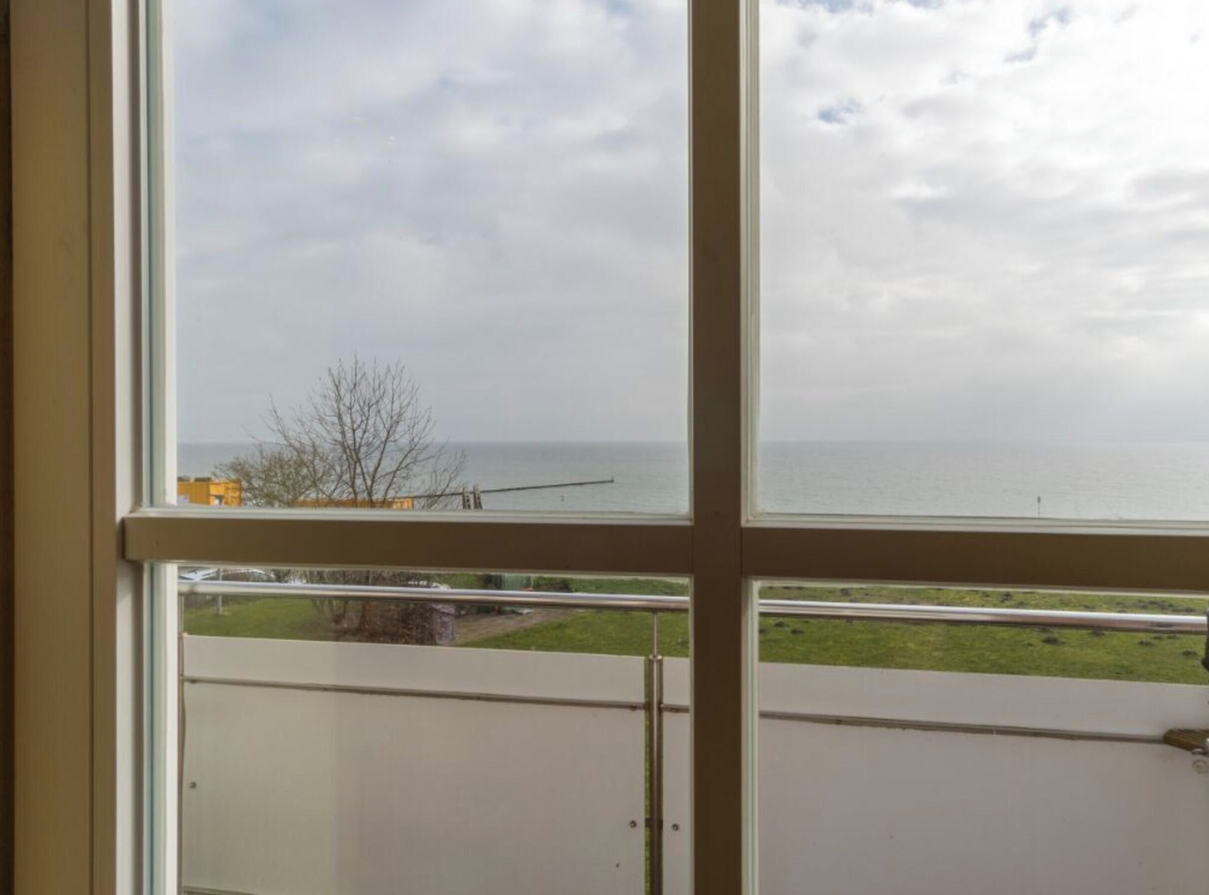 A view from a window with a clear sky and a body of water in the distance.
