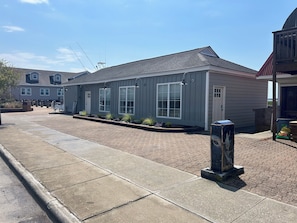 A residential building with a grey exterior, large windows, and a paved driveway. - Newly rennovated Two bedroom waterfront Get Away. (Morehead City)