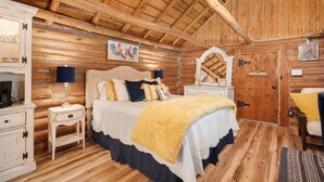 Quarto em estilo cabana de tronco com cama, mesas de cabeceira, cômoda e espelho.