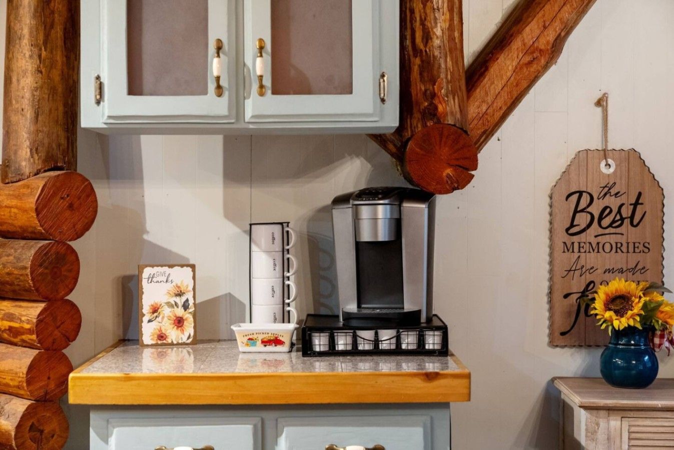 A kitchen counter with a coffee maker, a card with a floral design, and a wooden sign saying 'the Best Memories Are made for you.'