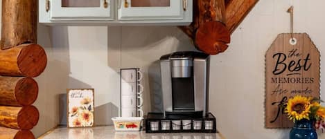 Eine Küchenarbeitsplatte mit einer Kaffeemaschine, einer Karte mit floralem Muster und einem Holzschild mit der Aufschrift 'the Best Memories Are made for you'.