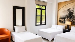 A hotel room with two beds, a chair, a painting, and a window with a view.