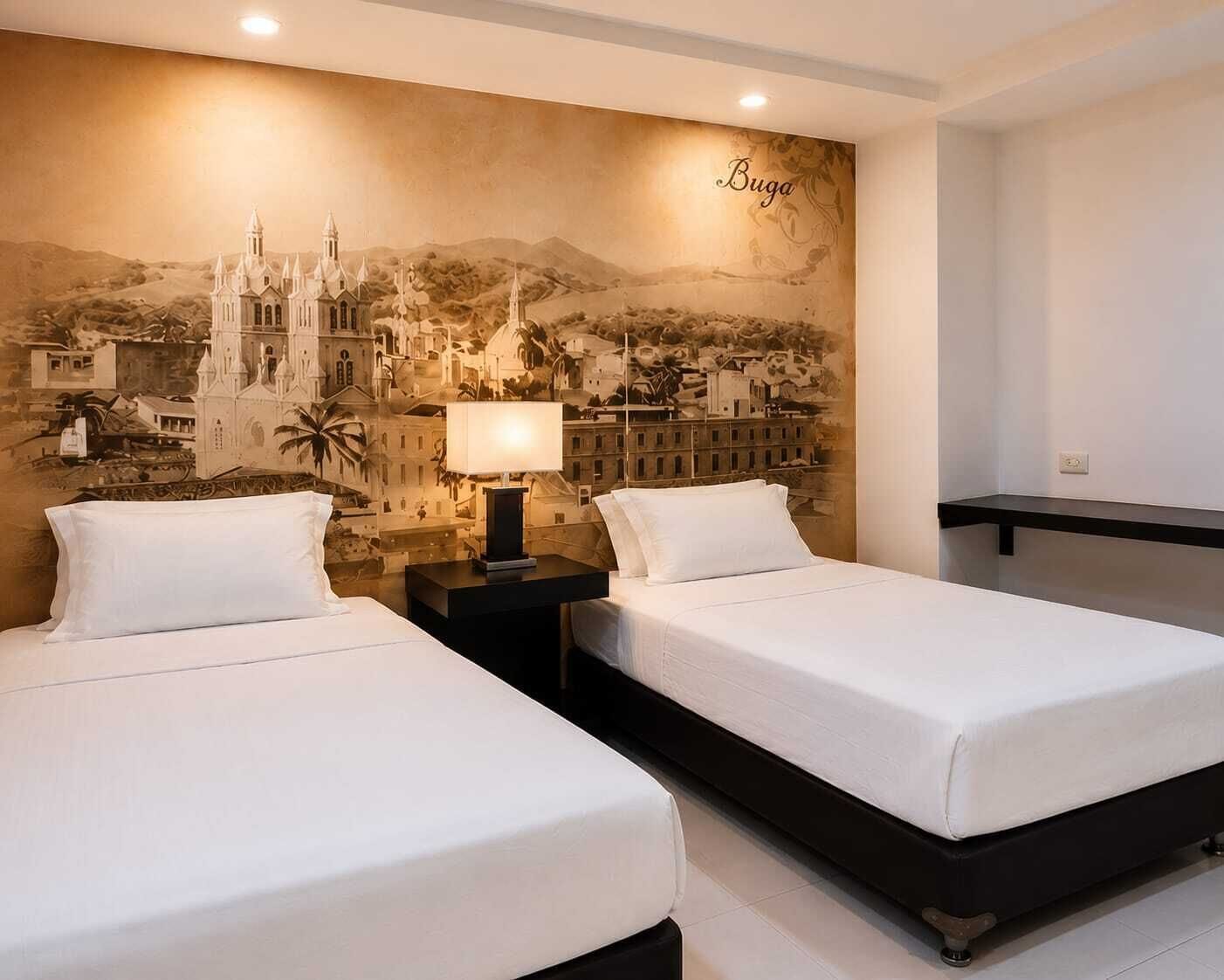 A hotel room with two beds, a nightstand with a lamp, and a mural of a cityscape on the wall.