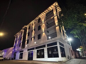 Un hotel a più piani con facciata moderna, ampie finestre e un balcone ai piani superiori.