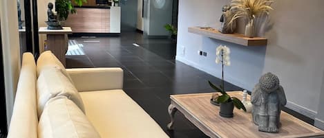 Una sala de estar moderna con un sofá, una mesa de centro y objetos decorativos.