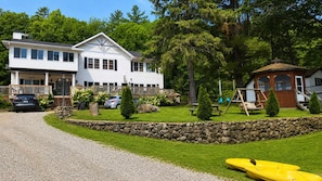 A two-story building with a stone retaining wall, a picnic area, and a swing set.