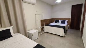 Une chambre d’hôtel comprenant un lit, une table de chevet, une armoire et un petit meuble de chevet.