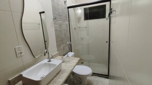Une salle de bain avec une douche, un lavabo et des toilettes.