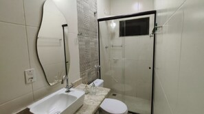 Un bany amb rentatge, vàter i zona de dutxa.