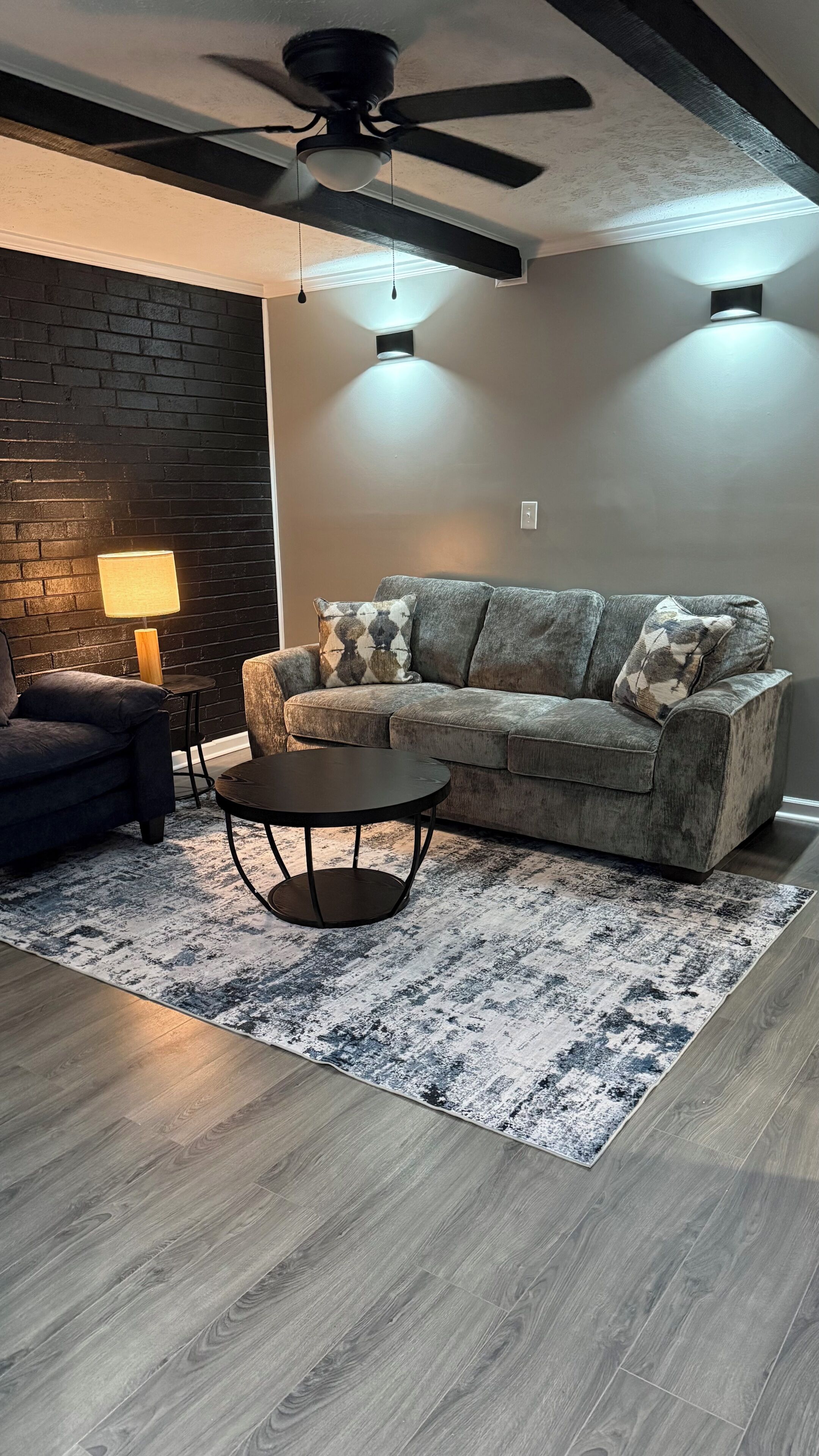 Un salon moderne avec un canapé, une table basse et un tapis à motifs.