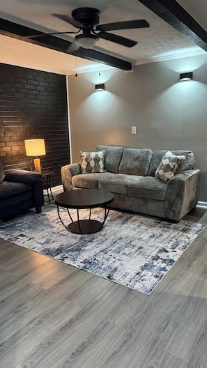 Un salon moderne avec un canapé, une table basse et un tapis à motifs.