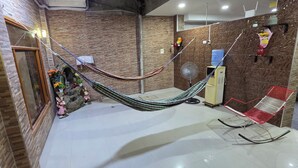 A room with a hammock, a fan, and a red chair. - Ximena's House: It offers the space and freedom your family needs. (Iquitos)