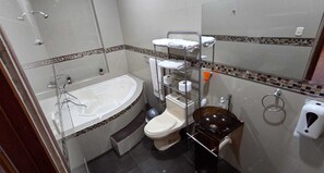 Um banheiro com banheira, vaso sanitário e pia.