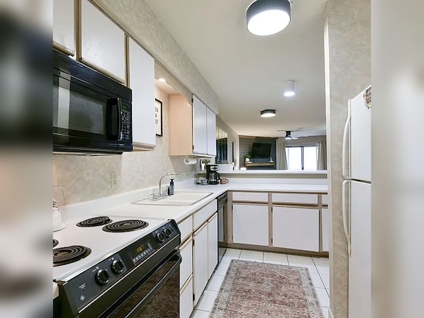 A compact kitchen with a stove, microwave, sink, and cabinets. - 2BR/2BA Taneycomo Lake Views +Resort Perks + Pet Friendly (Branson)