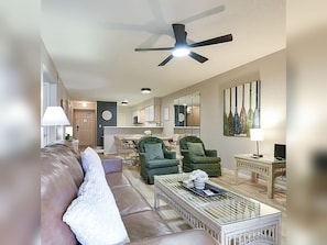 A living room with a ceiling fan, a sofa, armchairs, a coffee table, and a dining area with chairs and a table. - 2BR/2BA Taneycomo Lake Views +Resort Perks + Pet Friendly (Branson)