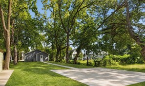 A residential area with a single-story house, a well-maintained lawn, and a clear sky.