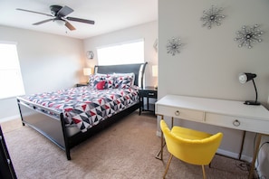 A bedroom with a bed, a desk, a chair, a ceiling fan, and decorative wall art. - 5-Bd Paradise Palms Townhome  Near Disney (Kissimmee)