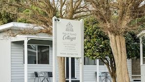 A sign for Phillip Island Cottages advertising fully self-contained, air-conditioned accommodations with 1, 2, or 3 bedrooms. - Phillip Island Cottages (Cowes)
