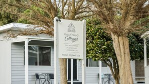 Señal para Phillip Island Cottages que anuncia alojamiento completamente equipado y con aire acondicionado, con 1, 2 o 3 habitaciones.