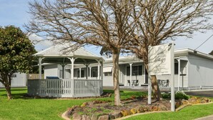 A bungalow-style building with a covered porch and a sign indicating it is part of Phillip Island Cottages. - Phillip Island Cottage 1 (Cowes)