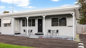 En envåningsbyggnad med en veranda, två fönster och en dörr.