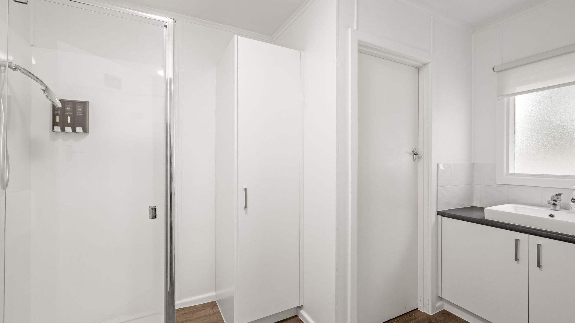 A bathroom with a shower, a toilet, and a sink.