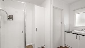 A bathroom with a shower, a toilet, and a sink. - Phillip Island Cottage 5 (Cowes)