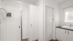 A bathroom with a shower, a toilet, and a sink. - Phillip Island Cottage 5 (Cowes)