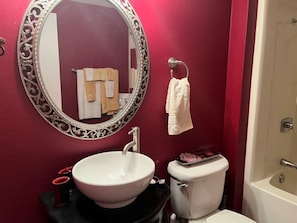 Een badkamer met een witte wastafel, toilet en bad.