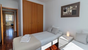 A hotel room with a bed, bedside table, and a wardrobe. - Vrbo Property (Câmara de Lobos)