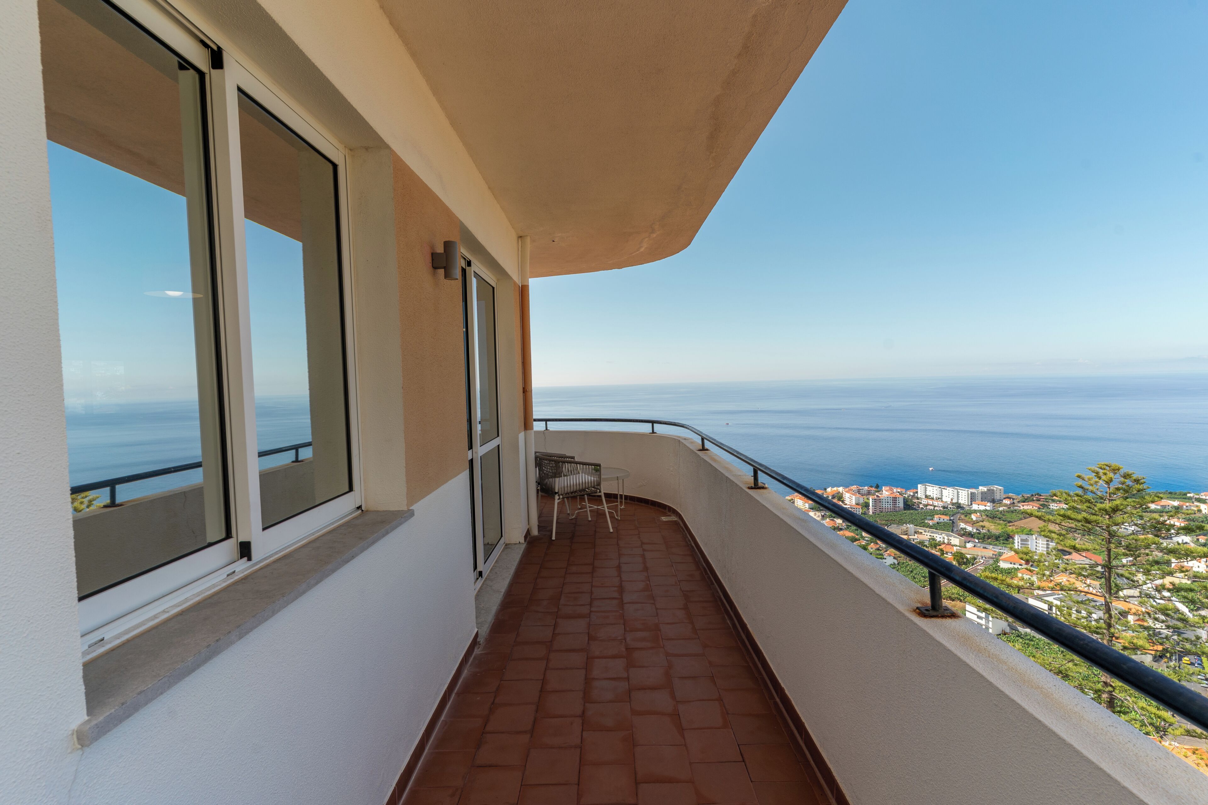 Un balcón con vista al mar y edificios.