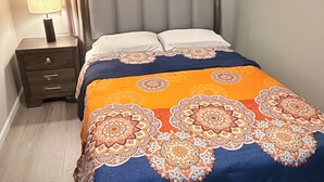 A bedroom with a bed, a nightstand, a lamp, a ceiling fan, and a window with curtains. - The Cove #4. Rare find. Comfy 2Bedroom apartment in soothing Rockingham with AC. (Rockingham)