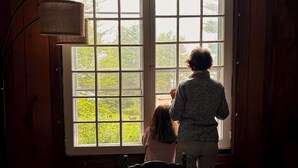 Una stanza con un letto, una finestra e una lampada.