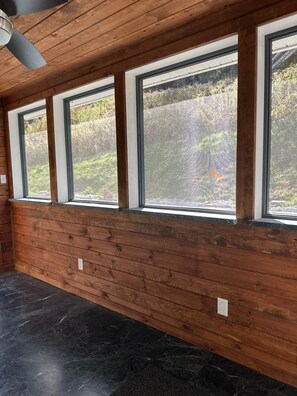 A room with wooden paneling and a series of windows. - Green Stone Getaway, cozy cabin close to Killington! (Bethel)