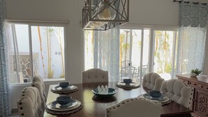 Un comedor con una mesa grande, sillas y una lámpara colgante.