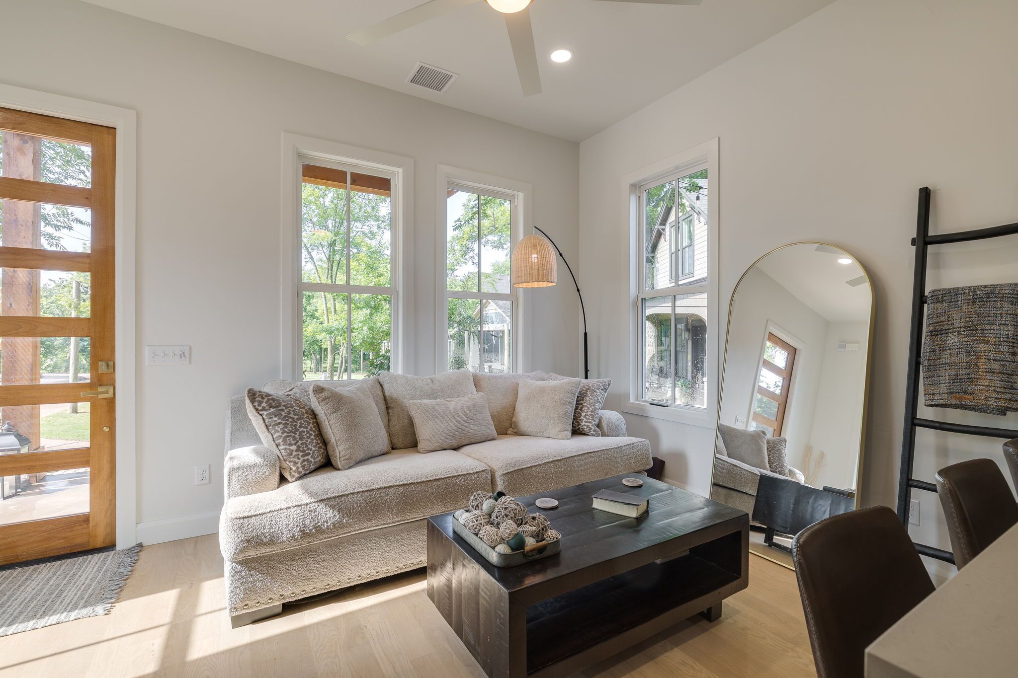 A modern living room with a sofa, coffee table, and a large mirror.