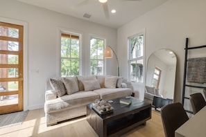 A modern living room with a sofa, coffee table, and a large mirror.