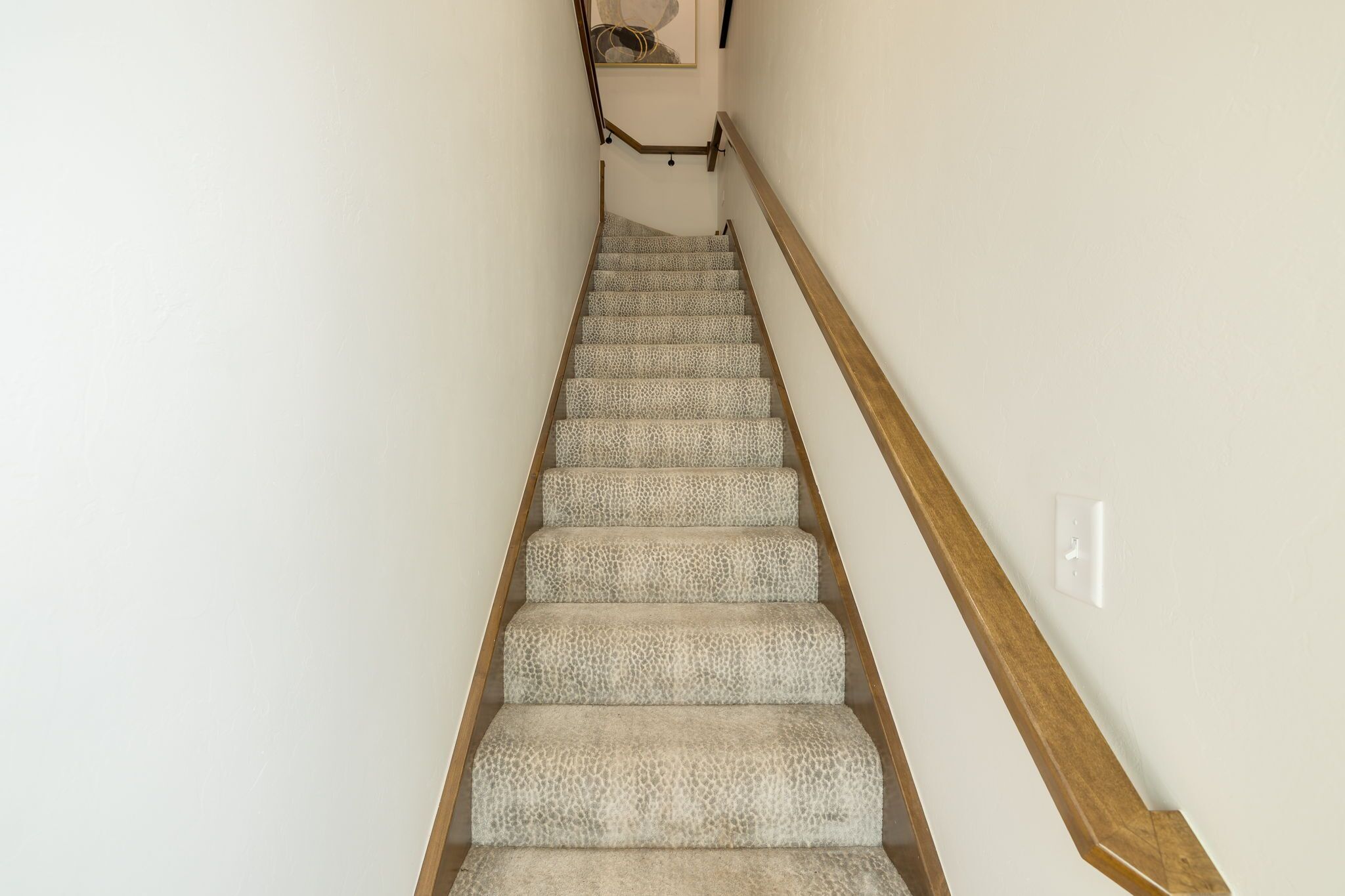 A staircase with carpeted steps and wooden handrails.