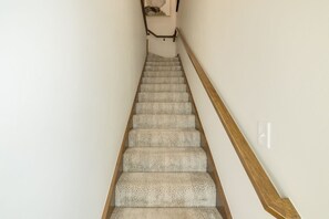 Una escalera con peldaños alfombrados y barandillas de madera.