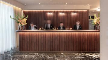 A reception desk with a wooden finish and a marble floor.