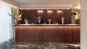 A reception desk with a wooden finish and a marble floor.
