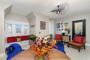 A modern living room with a round table, blue chairs, and a decorative vase. - Minutes to Capitol & UPMC  w/Monthly Parking (Harrisburg)