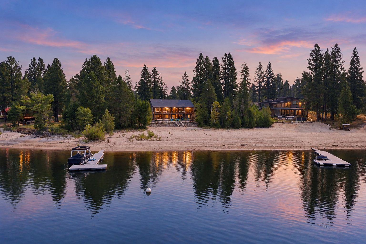 A lakeside cabin with a dock, surrounded by trees and a clear sky.