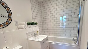 Un baño moderno con inodoro, lavamanos y bañera.